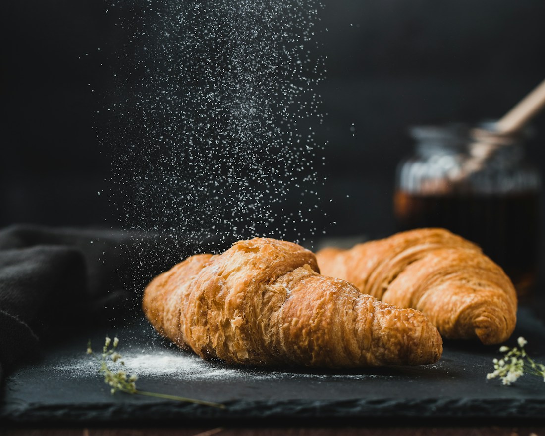 Golden, flaky croissants piled in a bakery